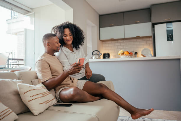 istock Young couple looking at smartphone at home 2157490059