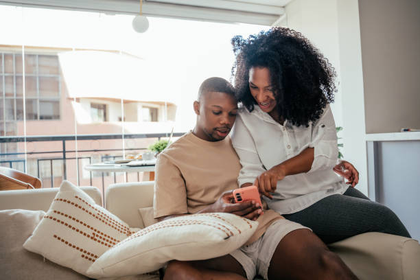 istock Young couple looking at smartphone at home 2157490061