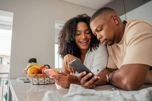 istock Young couple looking at smartphone at home 2157490062