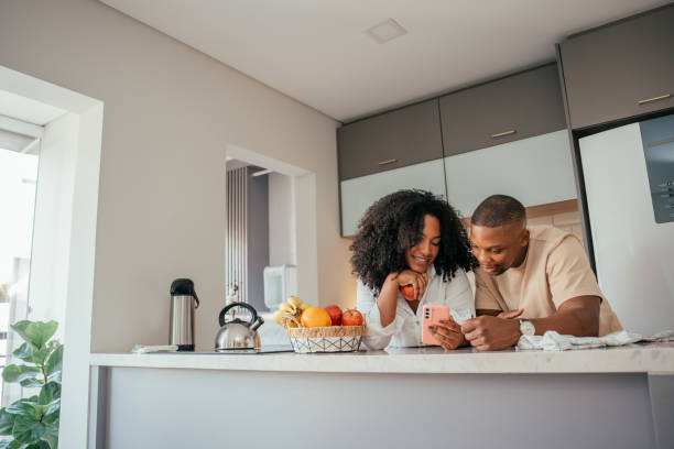 istock Young couple looking at smartphone at home 2157490063