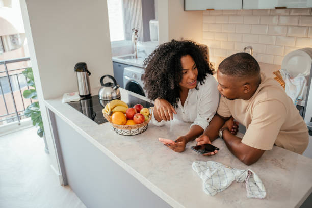 istock Young couple looking at smartphone at home 2157490064