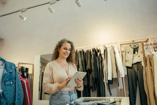 istock Entrepreneurial woman in her clothing store, using tablet 2157490890