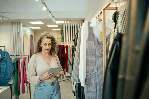 istock Entrepreneurial woman in her clothing store, using tablet 2157490898
