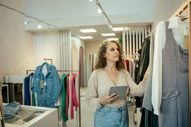 istock Entrepreneurial woman in her clothing store, using tablet 2157490899
