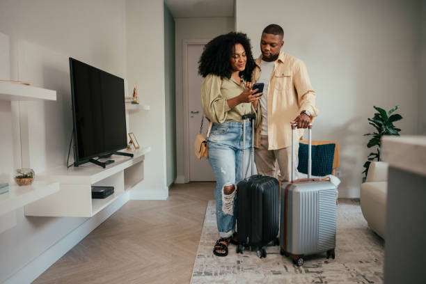Couple leaving home with suitcases for travel