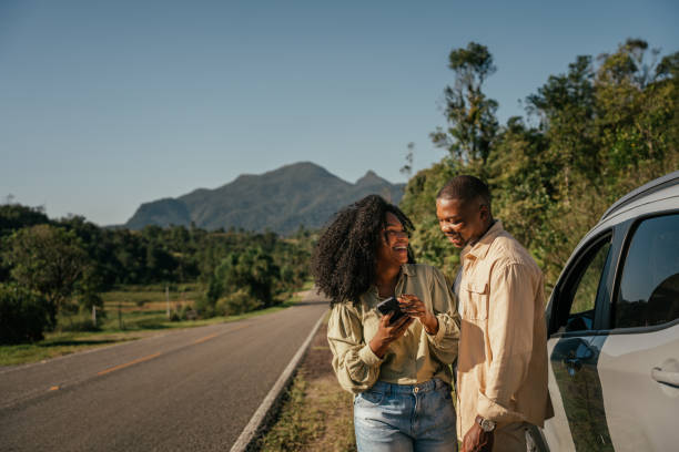 Couple next to car using smartphone