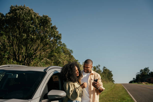 istock Couple next to car using smartphone 2157491748