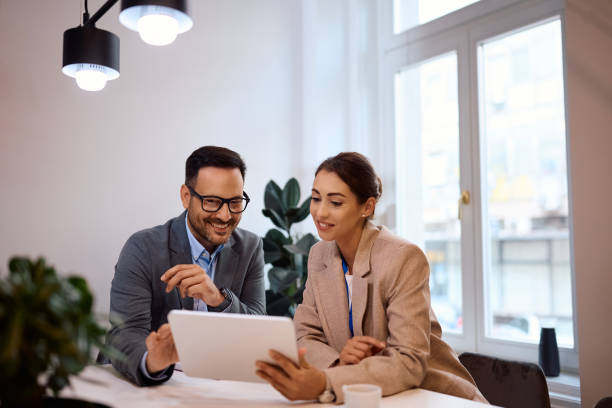 istock Happy business colleagues working on digital tablet in the office. 2157491772