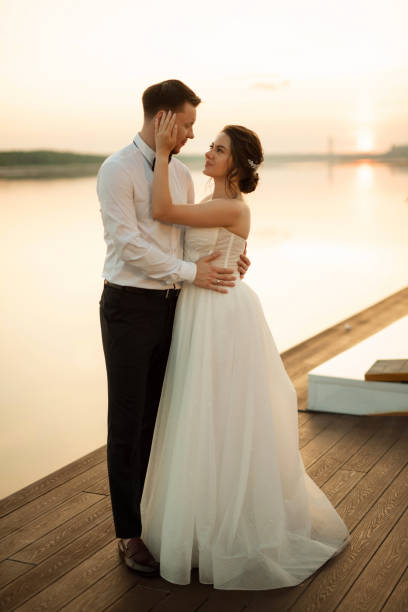 istock bride and groom against the backdrop of a yellow sunset 2157494564