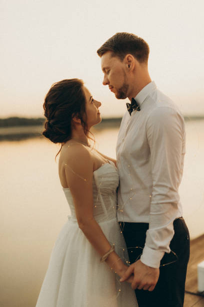 istock bride and groom against the backdrop of a yellow sunset 2157494582
