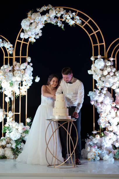 istock newlyweds happily cut and taste the wedding cak 2157494687