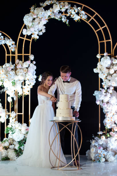 istock newlyweds happily cut and taste the wedding cak 2157495377