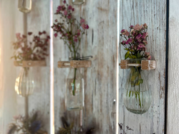 Clear glass vase in the rain on a wooden table with plants background