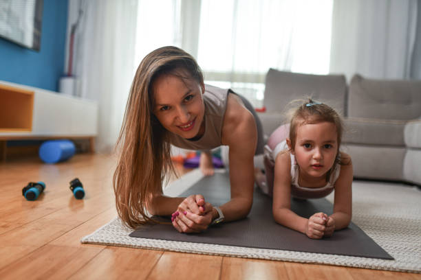 istock Full Focus By Mother And Daughter While Performing Plank Exercise At Home 2157501477