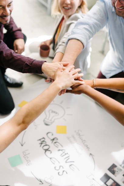 istock Happy team putting their hands together for success 2157501992