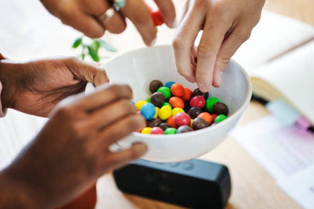 istock Hands taking sweet candies from a cup 2157502627