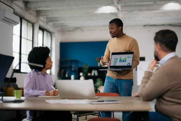istock Businessman explaining data on laptop screen to colleagues in startup meeting 2157502930