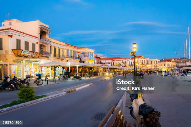 アイギナ島のアイギナ島にあるギリシャのアイギナのマリーナと旧市街に沿った海辺のメイン遊歩道であるディモクラティアス通り沿いのライトアップされた