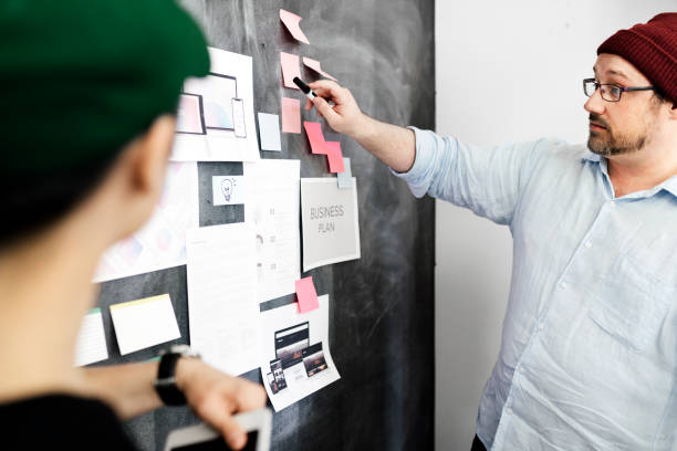 istock Leader in a startup company brainstorming using a blackboard 2157507753