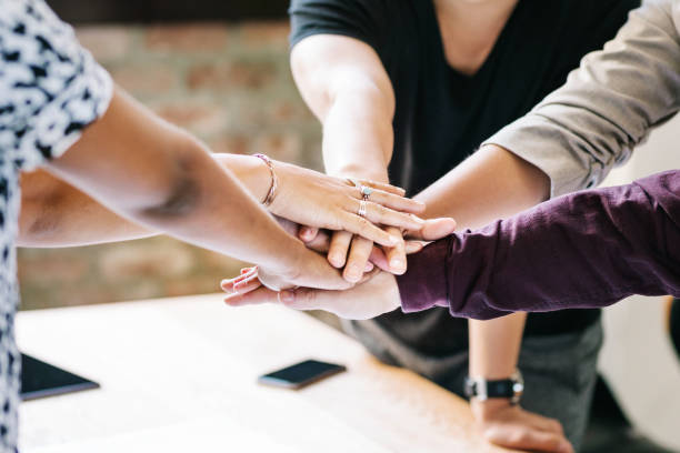 istock Happy team putting their hands together for success 2157508940