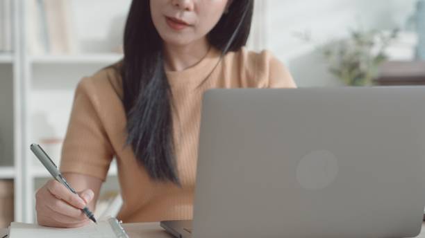 istock Asian young woman working from home,  e-learning at home 2157512029