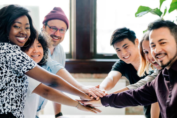 istock Happy team putting their hands together for success 2157514149