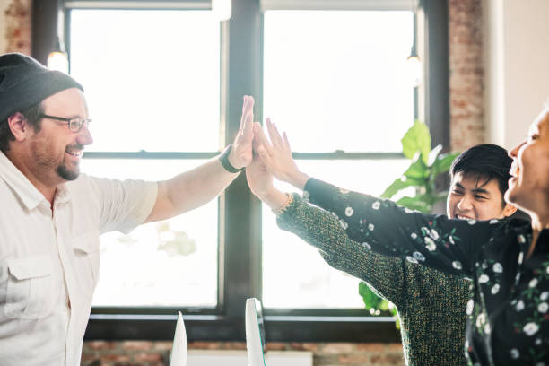 istock Happy diverse colleagues in a startup company doing a high five 2157515272