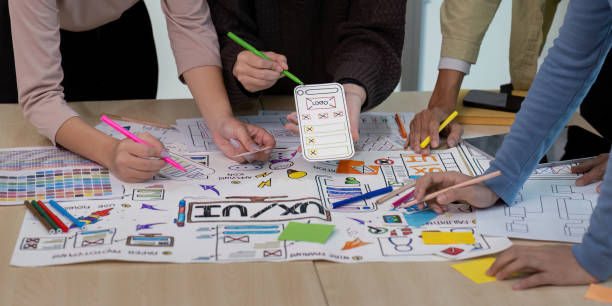 istock collaboration UX Developer and UI Designer Brainstorming Session with Creative Sketches and Prototypes on a Table 2157516398