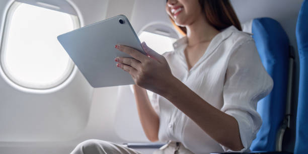 istock Business Woman Traveling on Airplane Using Tablet for Work, Modern Professional in Flight, Corporate Travel, Technology and Connectivity, Productive Journey, Business Trip, In Flight Work 2157519966