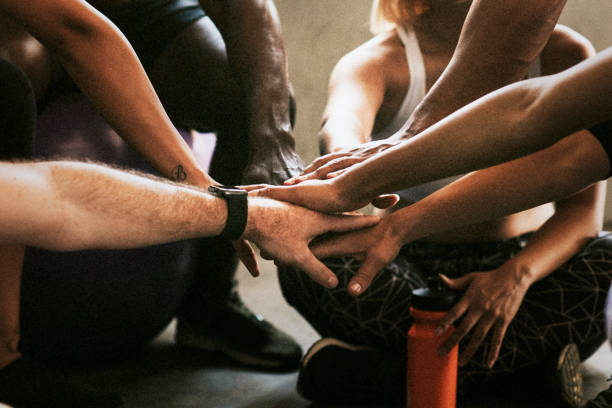 istock Sportive people stacking hands in the middle 2157520939