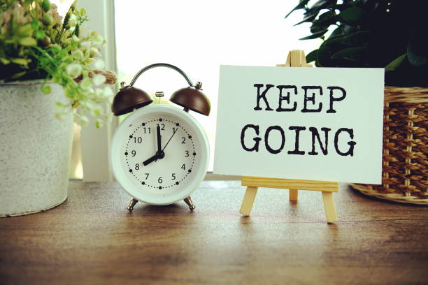 istock Keep going text message on paper card with wooden easel on wooden table background, inspiration motivation concept 2157521838