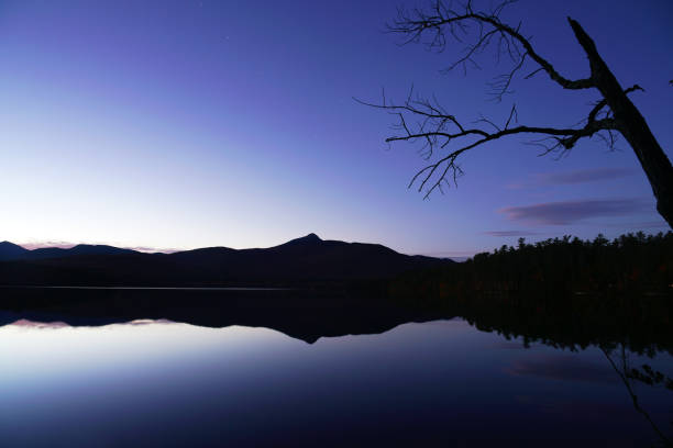 mountain reflection in the calm lake under dusk dark sky