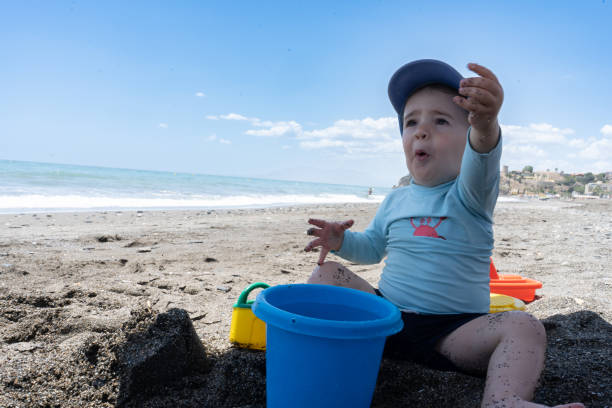 istock baby on the beach playing 2157523244