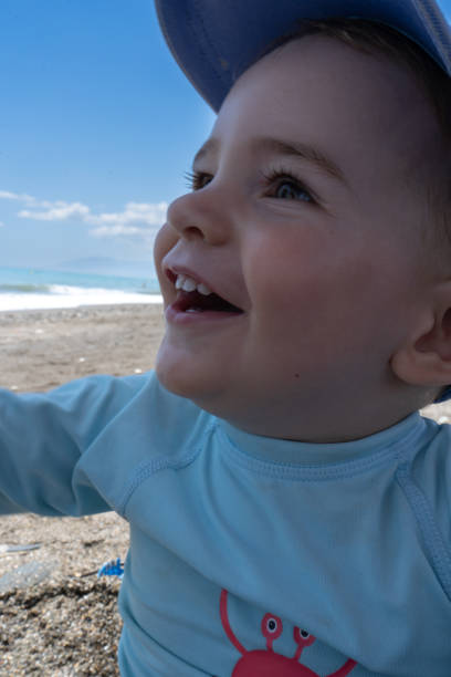 baby on the beach smiling and playing