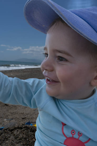 baby on the beach smiling and playing