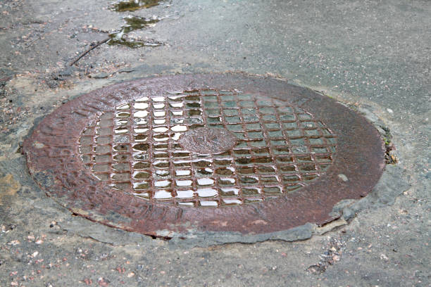 istock Wet sewer manhole in the asphalt. 2157524307
