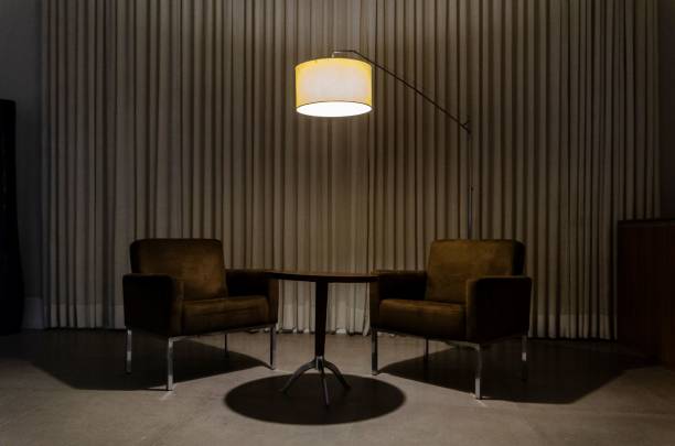 istock Modern interior with two brown armchairs, a small table, and a floor lamp illuminating the scene 2157528924