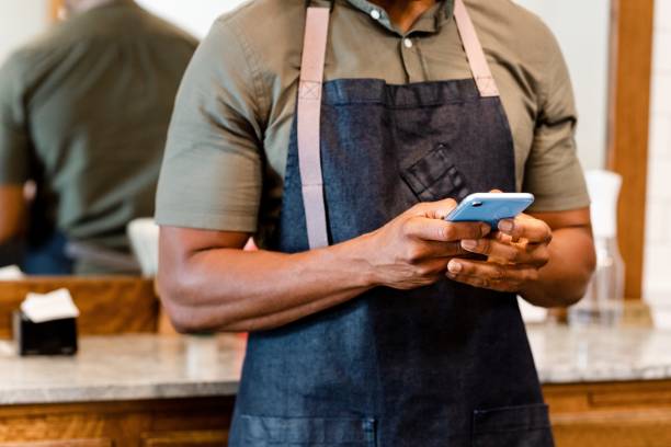 istock Barber texting in barber shop 2157532855