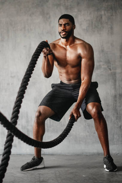 istock Muscular man working out on the battle ropes in a gym 2157533101