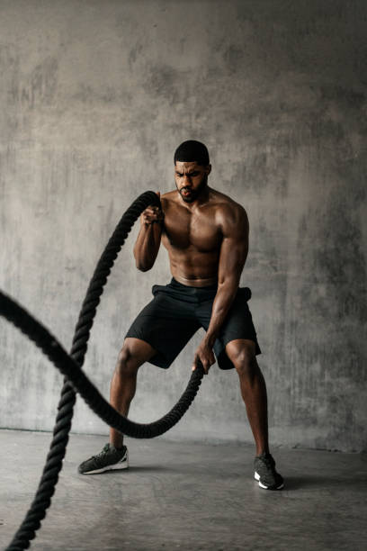 istock Muscular man working out on the battle ropes in a gym 2157533116