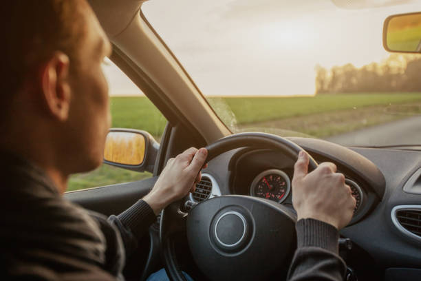 istock man driving car on road, hands on steering wheel 2157533655