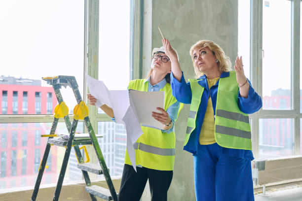istock Two female industrial workers at construction site discussing work plans 2157534695