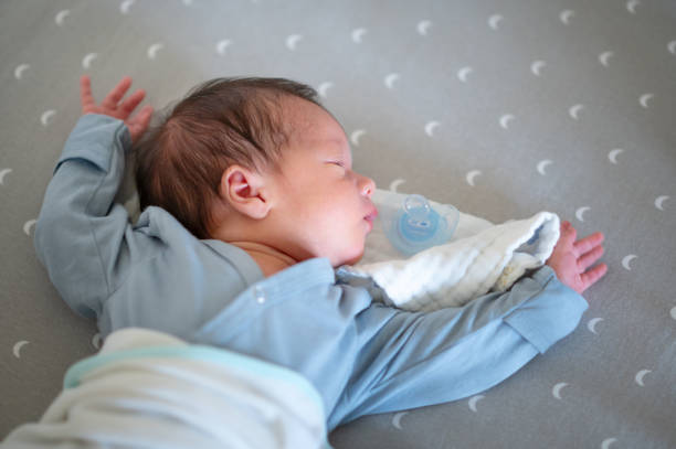 A serene image of a newborn baby sleeping peacefully with a pacifier, wrapped in soft blankets. The baby appears calm and comfortable.