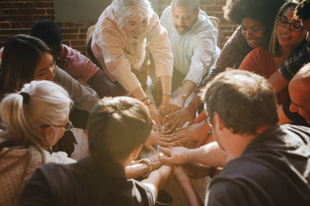 Group of diverse people stacking hands in the middle