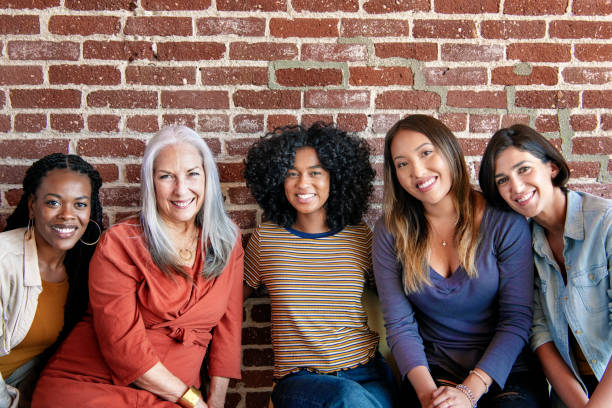 istock Diverse women sitting together by a brick wall 2157542125
