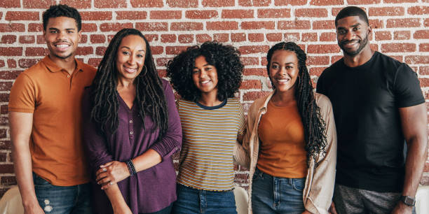 istock Cheerful black people standing in front of a red brick wall 2157542158
