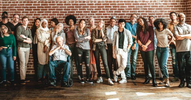 istock Group of diverse people standing in front of a brick wall 2157543948