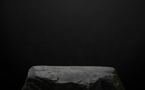 istock Stone Rock podium isolated on black background for product display presentation,Studio Background with Grey Sea Rock Shelf with rough surface texture with light, shadow on dark concrete background 2157544461