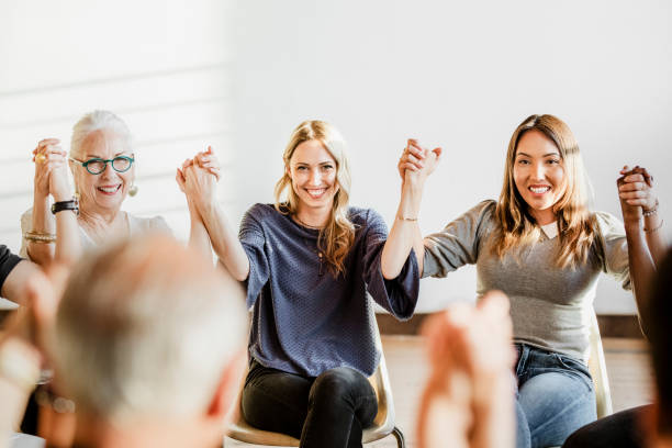 istock Group of diverse people holding hands up in the air 2157545794