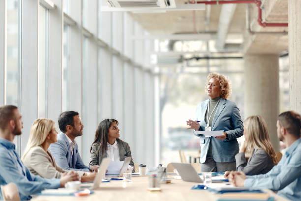 istock Happy mature CEO talking to her team about plans in the office. 2157545835